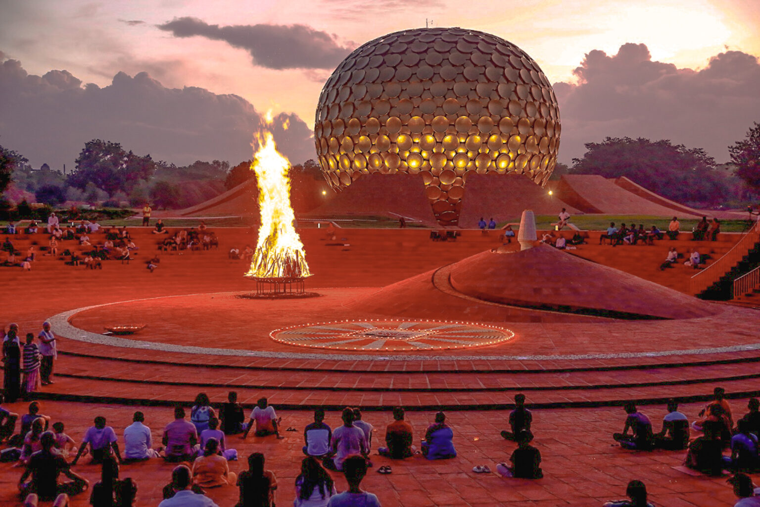 The Matrimandir at dawn with the bonfire in the Amphitheatre, Auroville